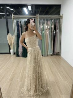 a woman taking a selfie in front of a mirror wearing a dress with sequins