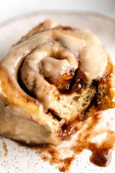 a cinnamon roll with icing on a plate