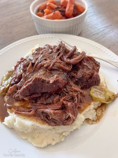 a white plate topped with meat and mashed potatoes