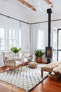 a living room with couches, chairs and a fire place in the middle of it