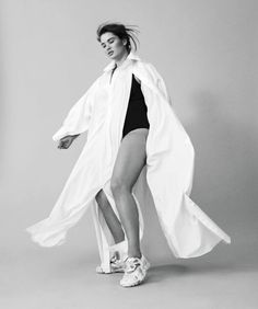 a woman in a white coat and black bathing suit