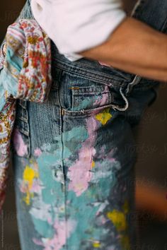 a person wearing an old pair of jeans with a flowered tie around their waist