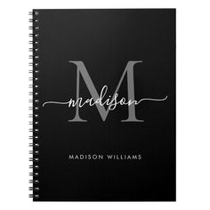 a black and gold monogramed notebook with the letter m in cursive writing