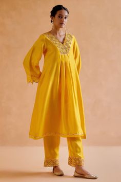 Yellow chanderi silk kurta featuring gold zardozi and thread embroidery on the neckline and delicate cut work on the sleeves. Paired with an embroidered pant, tribal motif tasseled dupatta and slip.
Components: 4
Pattern: Embroidered
Type Of Work: Zardosi
Neckline: V Neck
Sleeve Type: Long Cutwork
Fabric: Chanderi Silk, Silk Organza
Color: Yellow
Other Details: 
Kurta length: 44 inches
Model Height: 5ft 9inches, wearing size S
Occasion: Mehendi and Haldi - Aza Fashions V Neck Kurta, Kurta Pant Set, Silk Kurta, Embroidered Pants, Kurta With Pants, Thread Embroidery, Silk Organza, Cut Work, Pant Set