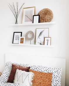 a bed topped with lots of pillows and pictures