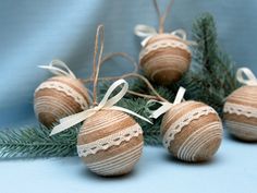 some ornaments are sitting on top of a tree branch and tied with twine string