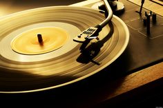 a close up of a record player with a yellow disk in the foreground and a black object on top