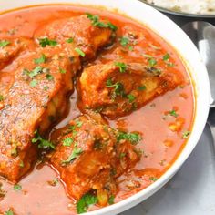 a bowl filled with meat and sauce next to rice