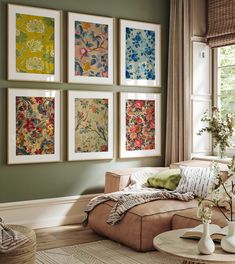 a living room filled with furniture and paintings on the wall above it's coffee table