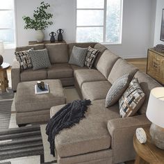 a living room filled with lots of furniture and pillows on top of it's couches