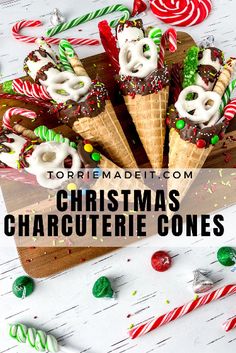 christmas character ice cream cones with candy canes and candies around them on a wooden board