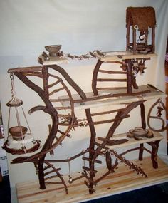 a wooden shelf that has some kind of sculpture on it's top and is made out of branches