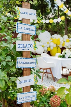 there are many signs on the wooden pole in the garden that read, gelato, limoonicelno and la fontainena