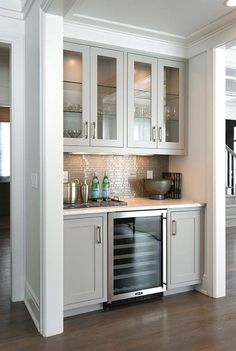 a kitchen with white cabinets and wood flooring in the middle of it is shown