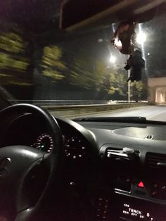 a person jumping in the air on a skateboard over a car dashboard at night