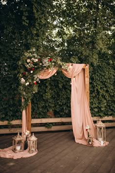 an outdoor ceremony setup with pink drapes and flowers