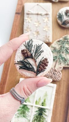 a person is holding a small piece of food with pine cones and firs on it