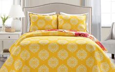 a bed with yellow and white bedspread in a room