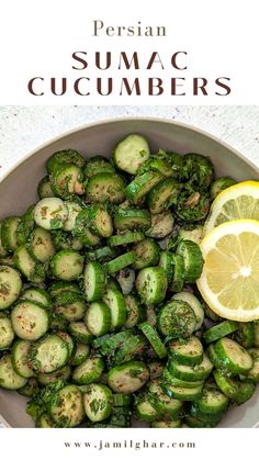 a white bowl filled with sliced cucumbers and lemon wedges