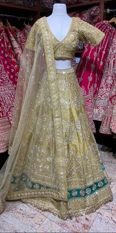 Glimmering Vegas gold embellished with floral in thread , sequins, zari & pearl work lehenga gives a royal appeal with similarly embroidered V neckline blouse and net dupatta. Sparkle, shimmer and all that glitz! Fabric: Silk Size: 38/M All preorders will be handled by a Nazranaa Bridal Consultant who will virtually discuss measurements and minor changes according to the client's specifications. Occasion: Wedding Ceremony or Reception. WASH CARE INSTRUCTIONS - Please Dry clean only when it is ap Embellished Art Silk Lehenga For Wedding, Gold Silk Bollywood Gown, Gold Silk Lehenga For Reception, Embellished Art Silk Gown For Reception, Gold Embellished Dola Silk Anarkali Set, Embellished Gold Dola Silk Anarkali Set, Embellished Gold Dola Silk Dupatta, Embellished Raw Silk Lehenga For Eid, Party Lehenga With Intricate Embroidery In Raw Silk