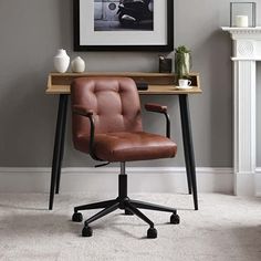 a brown leather office chair sitting in front of a wooden desk with a black metal frame