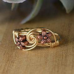 "Handmade Tiny Copper Tone Flower Beads, Sterling Silver, Yellow or Rose Gold Filled Wire Wrapped Ring; Custom Made to Size *This tiny copper tone metal flower beads and wire wrapped ring is handmade with two approximately 6mm in diameter metal flower beads and your choice of wire band. *This ring (as well as all the others in my shop) is custom made to any size from 4 to 14 including half and quarter sizes! *This ring can be made in Sterling Silver Filled Wire, Argentium Sterling Silver wire (t Witches Alphabet, Copper Flowers, Diy Wire Jewelry Rings, Wire Jewelry Patterns, Wire Jewelry Rings, Wire Wrap Jewelry Designs, Wire Wrapped Jewelry Diy, Diy Jewelry Inspiration, Wire Jewelry Designs