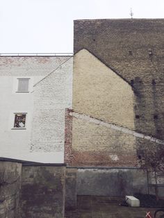 an old brick building next to a tall white building with a window on the side