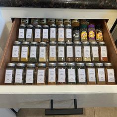 a drawer filled with lots of different types of spices and seasonings on top of a counter