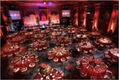 a large banquet hall with red lighting and round tables