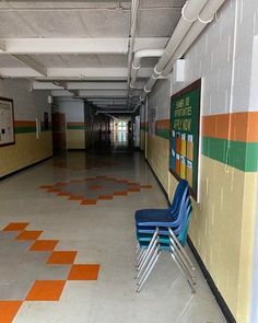 an empty hallway with chairs and posters on the wall