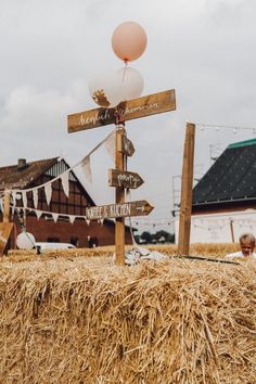 a wooden sign sitting on top of a pile of hay