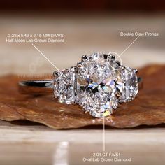 a close up of a diamond ring on top of a piece of wood with measurements