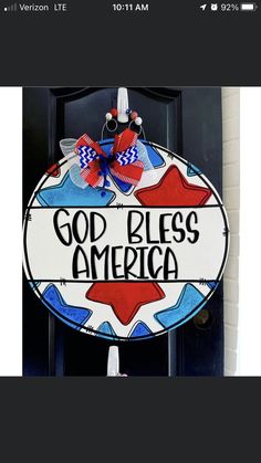 a sign that says god bless america hanging on a door with a red, white and blue bow