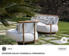 two white couches sitting next to each other in the grass