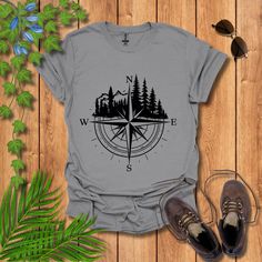 Set your compass for adventure with this stylish 'Navigational Compass & Forest' t-shirt! Perfect for explorers and nature lovers, this tee features a striking compass design encircled by majestic trees and mountain silhouettes. Whether you're trekking through the forest or just dreaming of your next outdoor adventure, this shirt is your ideal companion. Lightweight, comfortable, and visually captivating, it's designed to inspire your wanderlust and celebrate the great outdoors. Forest Graphic, Mountain Silhouette, Beyond The Horizon, Compass Design, Hiking Tshirt, Outdoor Shirt, Bold Design, Explore The World, Adventure Awaits