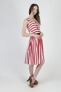 "Vintage 80s summer festival midi dress. Tailored tank bodice with button down front. Gathered elastic waist with sweeping skirt. Red and white striped cotton material. size estimate: M shoulders: - bust: 27\" - 36\" waist: 22\" - 34\" hips: - total length: 41\" * Visit the shop * https://www.etsy.com/shop/americanarchive Model is 5'9\" Belts and other accessories are not included." Retro A-line Dress For Day Out, Summer Cotton Midi Dress With Full Skirt, Summer Vintage Midi Dress, Retro Summer Midi Dress For A Day Out, Red 1950s Style Spring Dress, Summer Daywear Dresses With Full Skirt, Summer Dress Down Full Skirt Dresses, Summer Midi Dress With Full Skirt For Daywear, Cotton Full Skirt Summer Dress