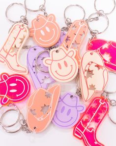 a bunch of key chains that are shaped like cartoon characters with faces and letters on them