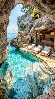 an outdoor swimming pool surrounded by rocks and water