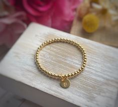 "THIS ITEM SHIPS FOR FREE! Introducing the Petite Initial Charm Bracelet. This listing is for one gold-filled bracelet made with 4mm beads with a hand-stamped initial charm. The charm is petite and measures 3/8\". Please review all of the photographs to see how the charm compares in size to a dime. This is the perfect way to add a little something to your gold-filled bead bracelet. I especially like this tiny charm for tweens/teens or when you want to add multiple charms to your bracelet. Please Gold Hypoallergenic Name Bracelet, Personalized Gold Beaded Bracelets, Personalized Gift Gold Beaded Round Bracelets, Personalized Gold Beaded Bracelet, Personalized Gold Round Beaded Bracelets, Hypoallergenic Gold Round Bracelets, Gold Stretch Bangle Bracelet With Letter Beads, Gold Stretch Bangle With Letter Beads, Adjustable Gold Beaded Bracelets As Gift