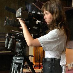 a woman holding a camera in front of a video camera