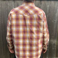 This well made Wrangler is a lovely color and has beautiful pearl snap buttons to complement the cowboy cut. Made in the USA, 100% cotton. Good condition with very little wear, just one tiny mark on sleeve.-Model size men’s Large-Approximate measurement when laid flat:24" armpit to armpit 20" shoulder to shoulder23" shoulder to cuff31" back of collar to hem Brown Rodeo Shirt With Button Closure, Brown Button Closure Shirt For Rodeo, Brown Button-up Shirt For Rodeo, Western Style Snap Button-up Shirt, Western Snap Button-up Shirt, Country Style Cotton Button-up Shirt, Western Style Cotton Flannel Shirt For Rodeo, Western Style Snap Button Shirt, Casual Shirt With Button Closure For Western-themed Events