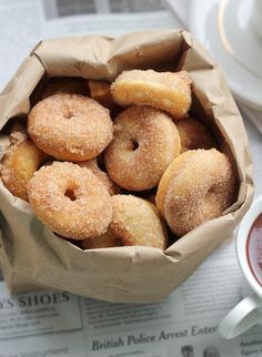 a paper bag filled with sugar covered donuts