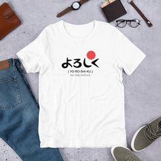 "Yoroshiku means \"please treat me favorably\". This is a funny gift idea for kids, men, and women. Cool t-shirt design featuring the Japanese word \"Yoroshiku\" Grab this Yoroshiku Shirt for your daughter, son, grandson, stepson, cousin, mom, dad, friend, coworker, or any other person who loves Japanese Culture. Perfect gift idea & present for Birthday, Graduation This t-shirt is everything you've dreamed of and more. It feels soft and lightweight, with the right amount of stretch. It's comfortable and flattering for both men and women.  * 100% combed and ring-spun cotton (Heather colors contain polyester) * Ash color is 99% combed and ring-spun cotton, 1% polyester * Heather colors are 52% combed and ring-spun cotton, 48% polyester * Athletic and Black Heather are 90% combed and ring-spu Funny White T-shirt As Gift, Funny White T-shirt Gift, Funny White T-shirt For Gift, White Text Print T-shirt As Gift, Japanese T Shirts, Japanese Lettering, Japanese Icon, Japanese Writing, Present For Birthday