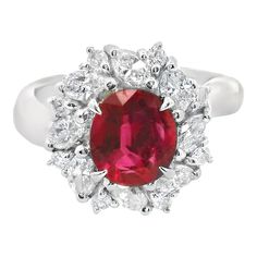 an oval shaped ruby and diamond ring with white diamonds around the band, set in 18k white gold