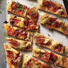 many slices of pizza are arranged on a baking sheet