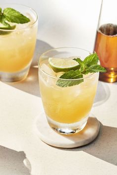 three glasses filled with lemonade and mint garnish on top of a table