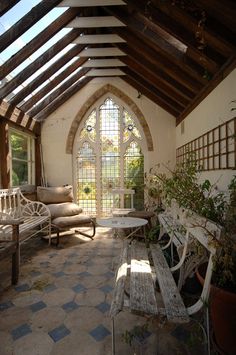 the inside of a building with benches and tables in front of a large arched window