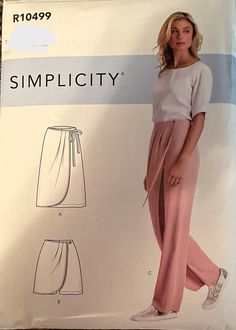 a woman in pink pants and white shirt standing next to a box with the words simpl city written on it