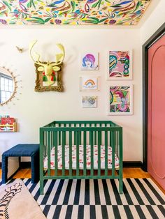 a baby's room with a pink door and green crib