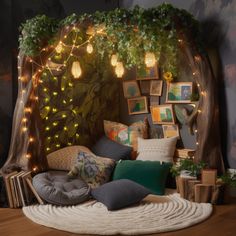 a bed with lots of pillows on top of it and lights hanging from the headboard